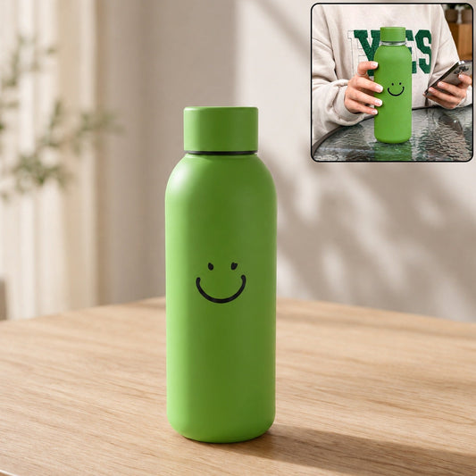 Green glass water bottle with a smiley face on a wooden table, with an inset showing a person holding a similar bottle.