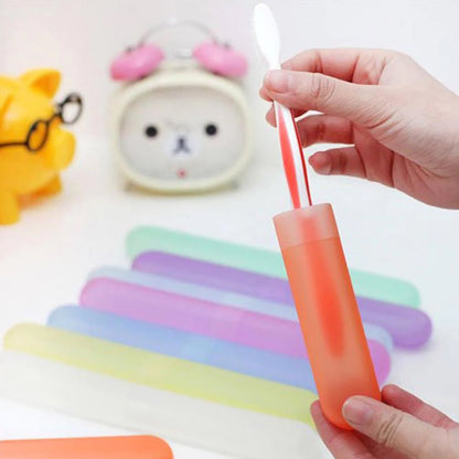 A hand inserts a white toothbrush into a translucent orange case, with other pastel-colored cases in the background.