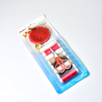 A clear plastic-packaged sewing kit containing thread, a thimble, scissors, and a needle holder.