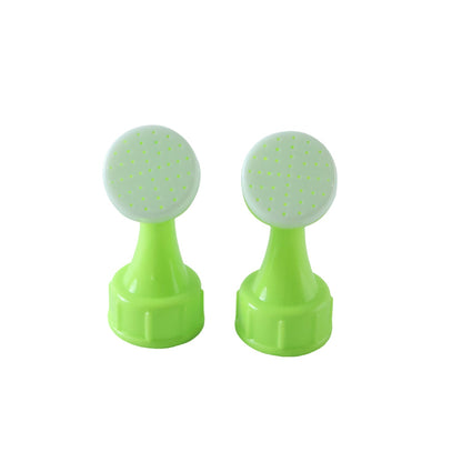 Two identical green plastic bottle top watering sprinklers with white tops are displayed on a white background.