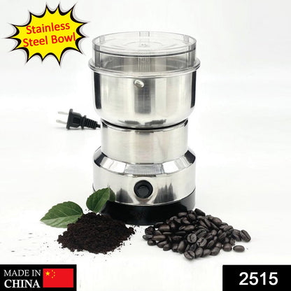 A stainless steel grinder with a clear lid and black base is displayed with coffee beans and ground coffee.