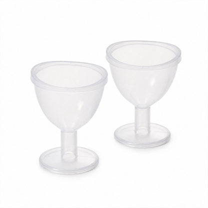 Two identical clear plastic eye wash cups with short stems and wide bases are displayed side-by-side on a plain white