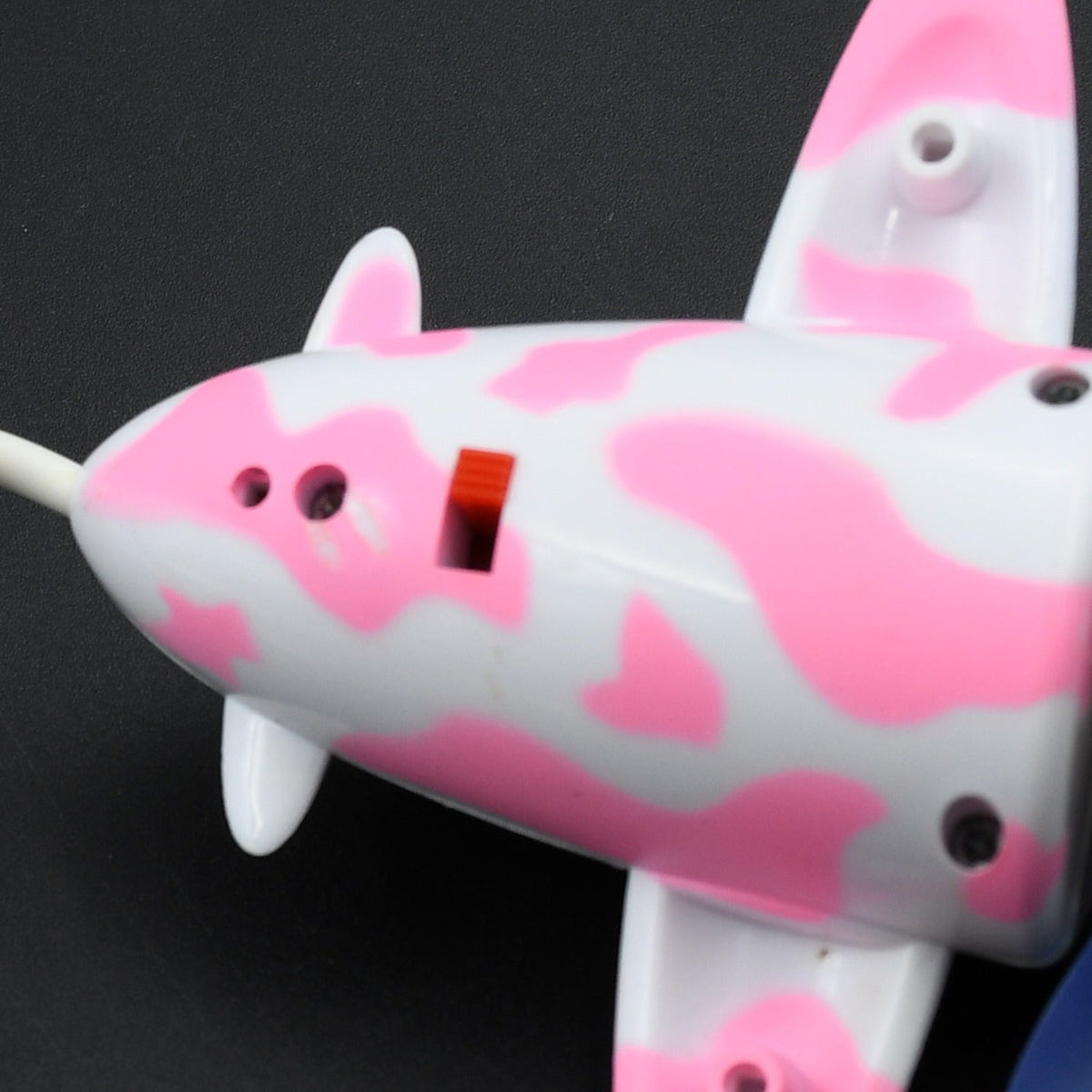 A close-up of the side of the pink and white airplane USB fan, showing its details and a small red switch.