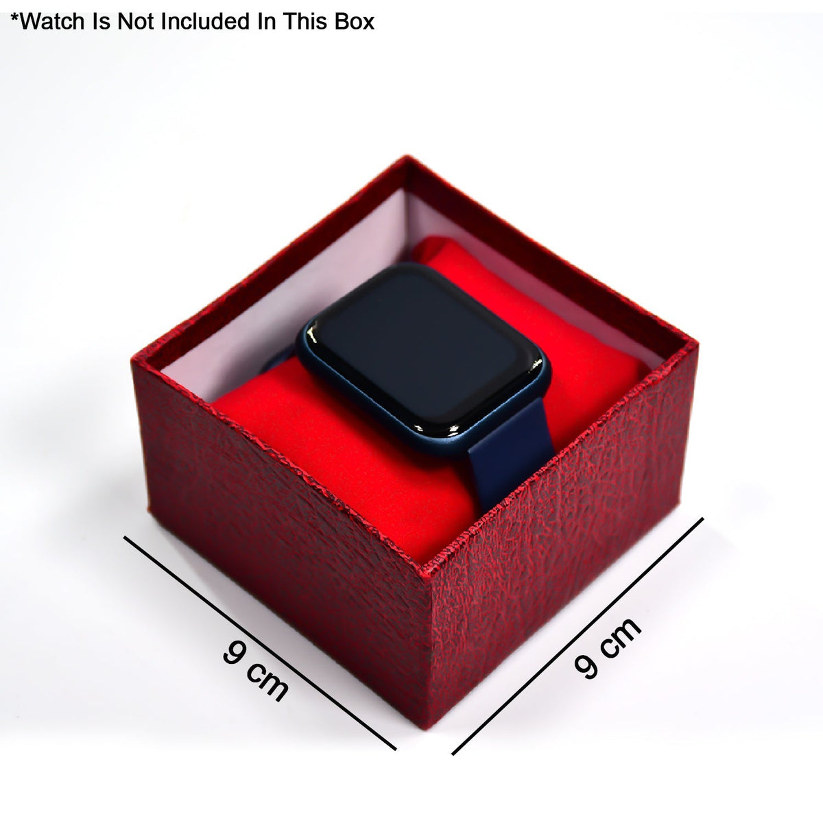 A dark blue smartwatch resting on a red velvet pillow inside an open red textured gift box, with 9 cm dimensions indicated.