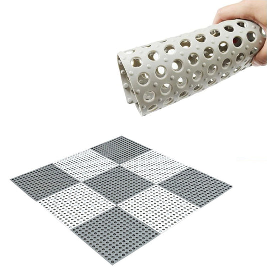 A hand holds a rolled-up grey anti-slip mat above a flat, checkerboard pattern of grey and white mats.
