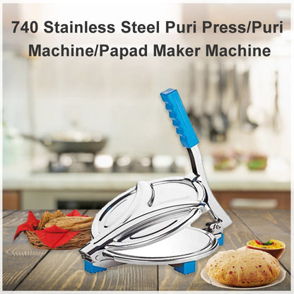 A stainless steel puri press with a blue handle sits on a wooden table with a kitchen background.