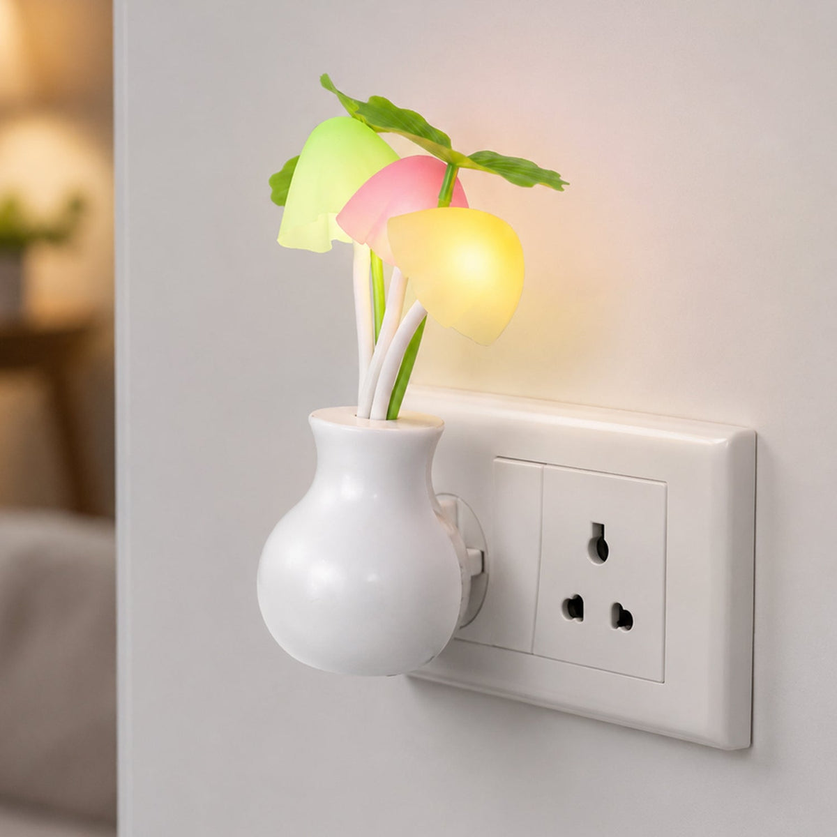 A white vase-shaped night light with glowing pink, yellow, and green mushroom-like lights plugged into a wall outlet in a
