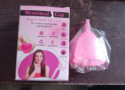 A pink silicone menstrual cup is shown on a white background, highlighting its flexible and soft material.