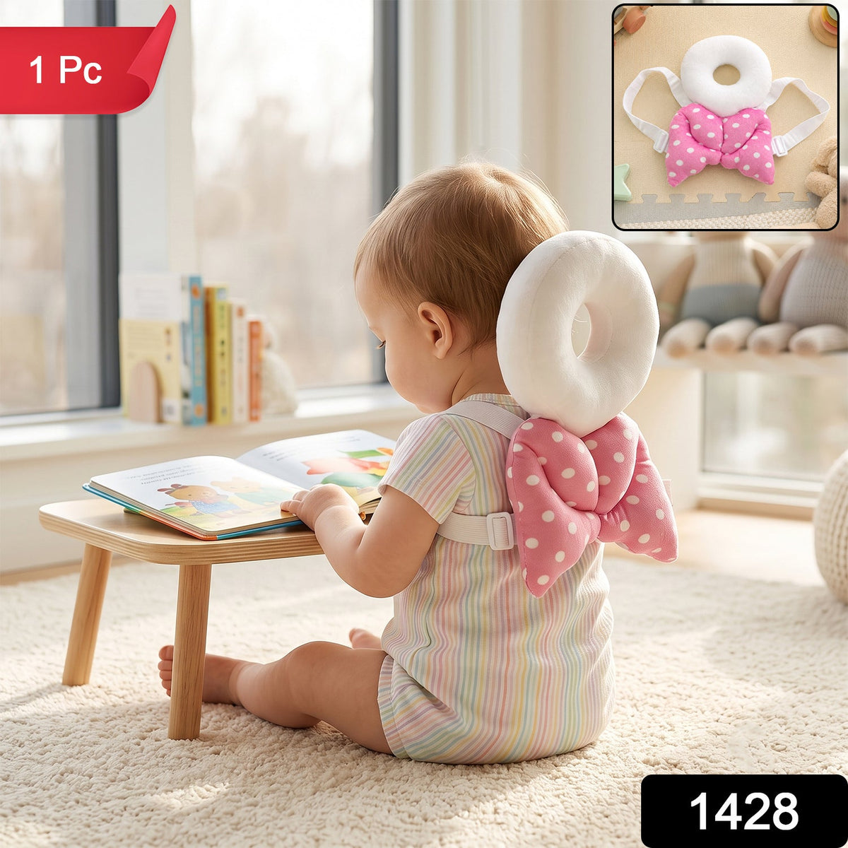 A baby wearing a pink and white polka dot head protector with angel wings sits on a rug reading a book