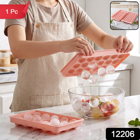 A person in an apron holds a pink ice ball tray, releasing clear ice balls into a glass bowl of fruit, with a '1 Pc' label.
