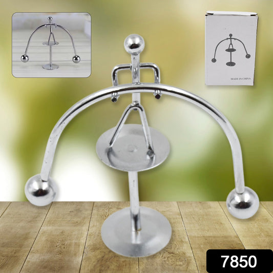 A silver metal balance toy with a small inset image of the toy and a white box with a diagram.